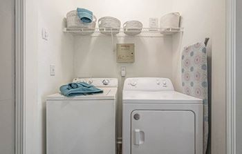 A white washing machine and dryer in a small laundry room.at The Atlantic Canton Ridge, Canton